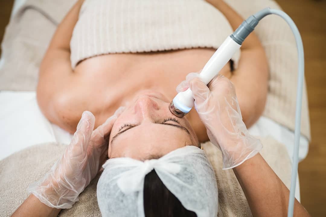 An aesthetician giving a professional facial treatment.